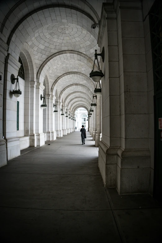 a man walks down a covered walkway at night