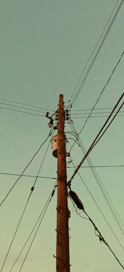 a telephone pole with many power lines in front of the sky