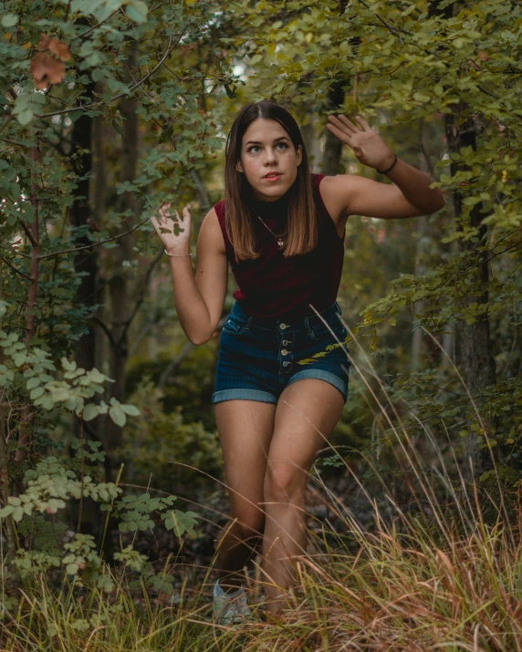 a woman in short shorts is walking through the woods