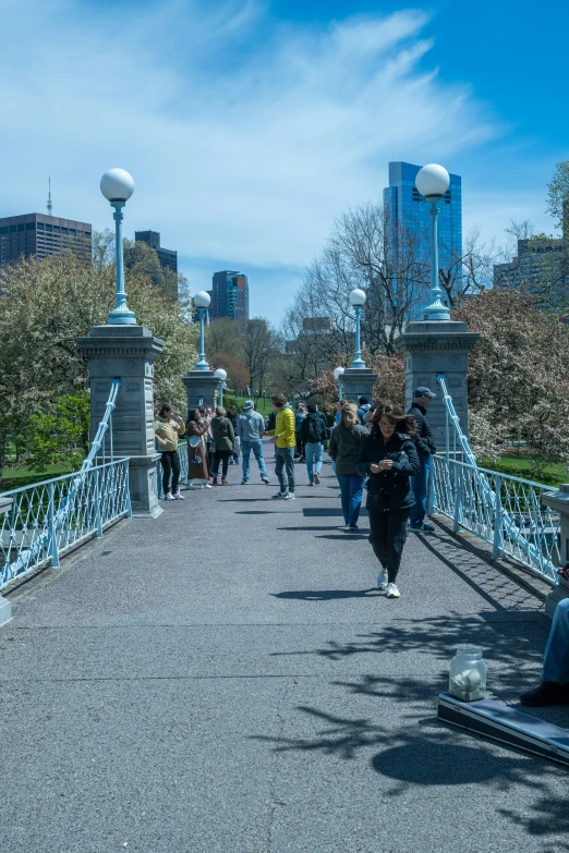 people walking over a bridge in the city
