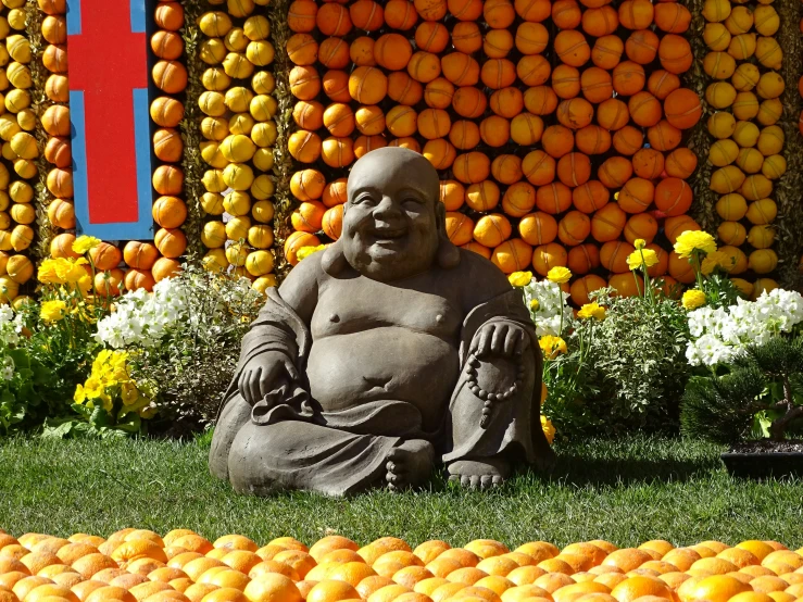 a statue sitting in front of several oranges on display