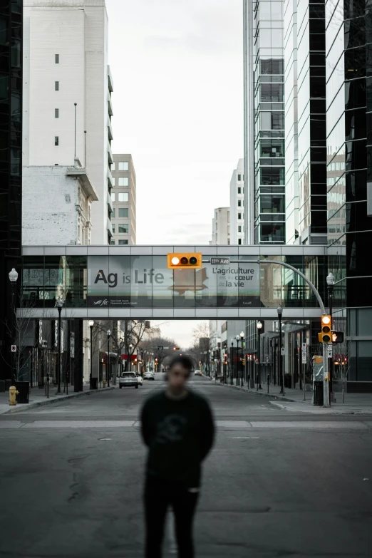 a person standing under a traffic light on an empty street