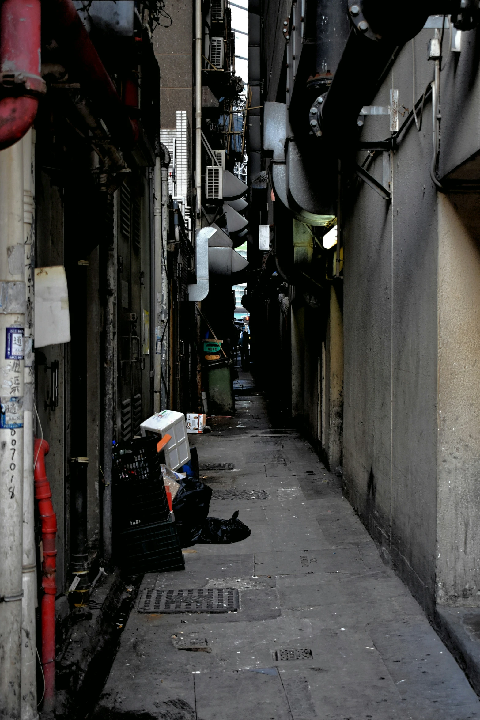 the back alley between two buildings holds umbrellas