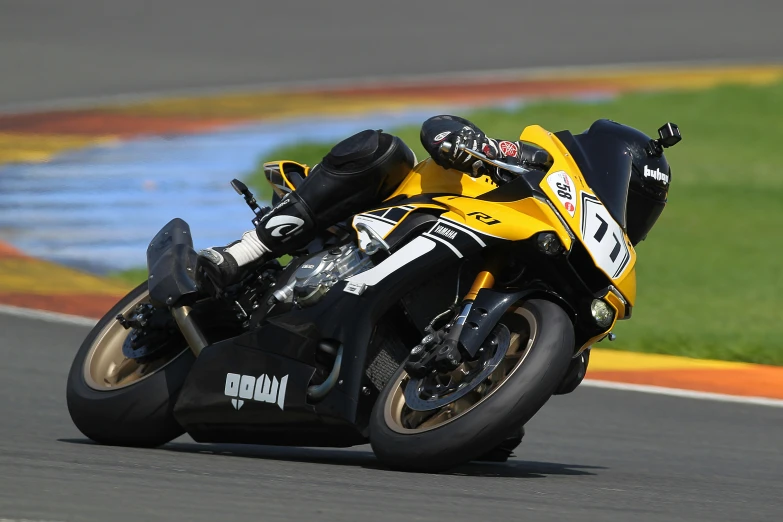 a man riding on the back of a yellow motorcycle