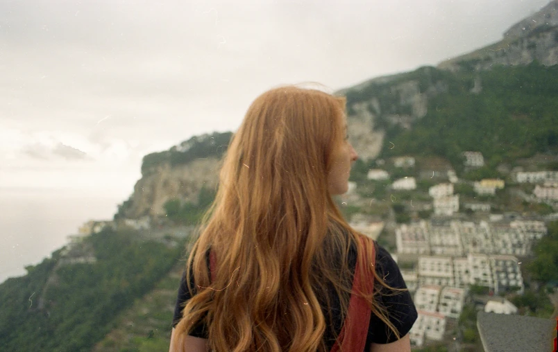 the red haired woman is overlooking the city of posit