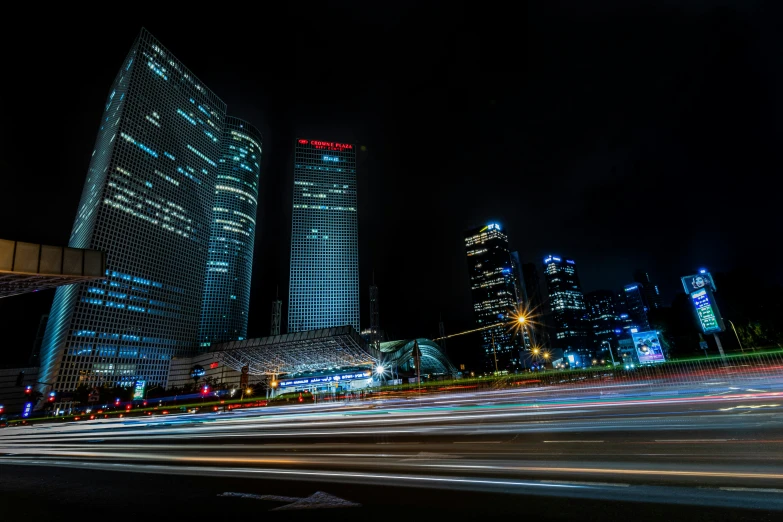 some tall buildings at night next to the road