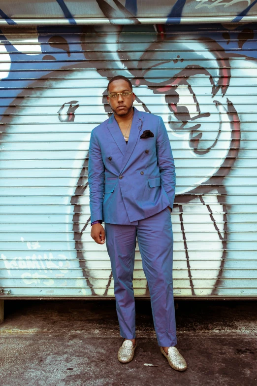 a man in a blue suit standing by a garage door