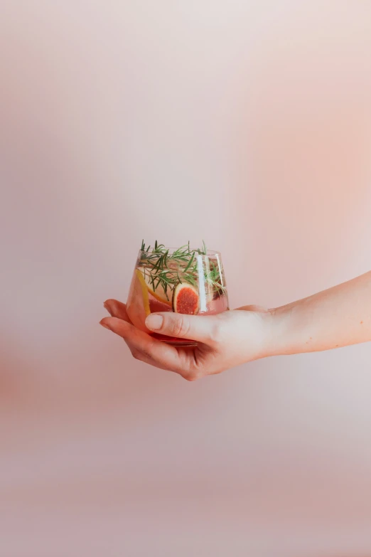 two hands each holding a mason jar filled with herbs