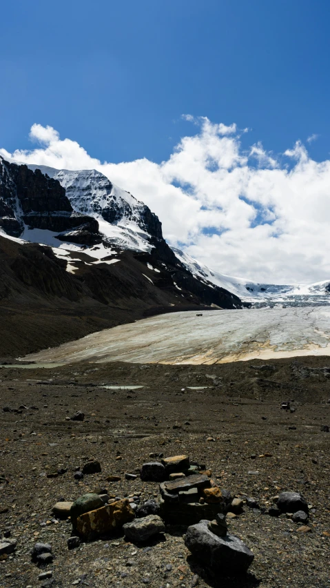 the sky is partly cloudy over the mountains and the ice - capped landscape