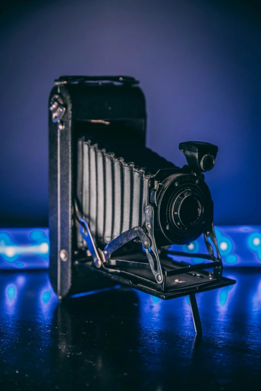 an old camera and tripod set on the table