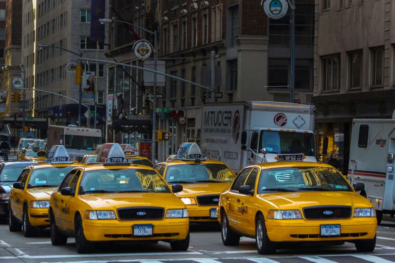 there are many yellow cabs on the street in new york