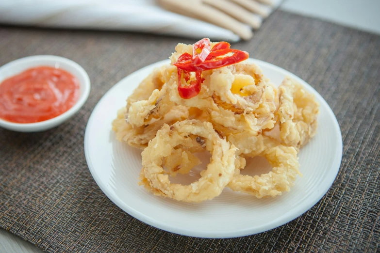 some onion rings on a plate with dipping sauce