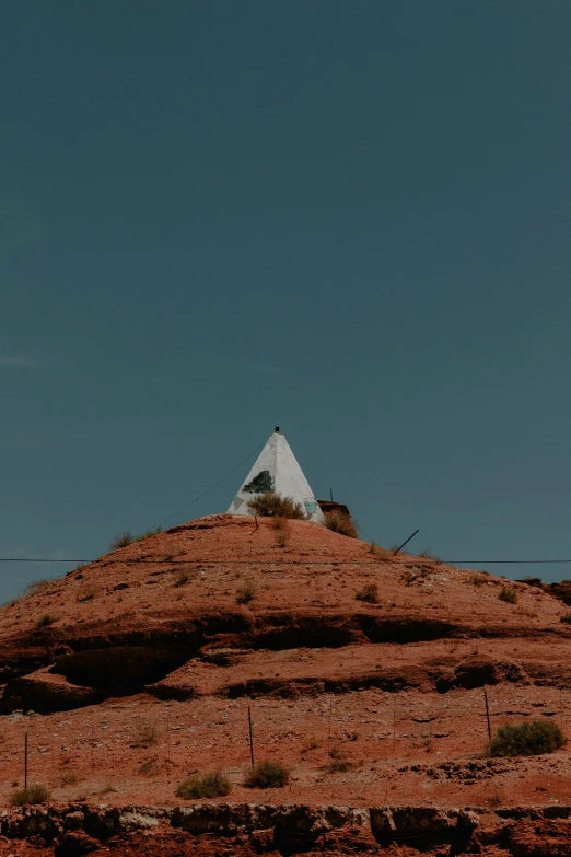 a small church stands on the top of a rocky hill