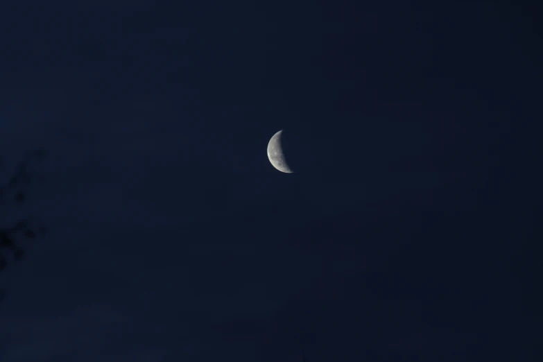 the moon is lit up with clouds in the sky