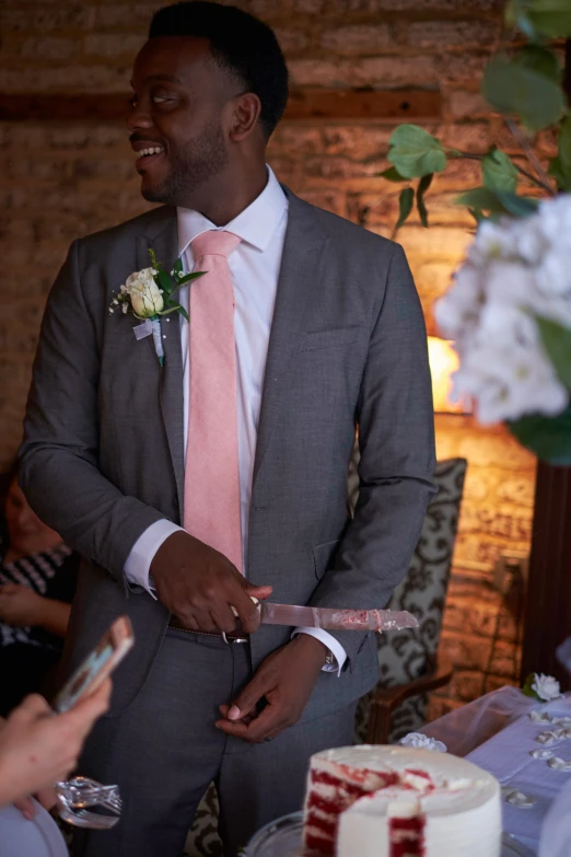 a man wearing a suit holding a pink tie