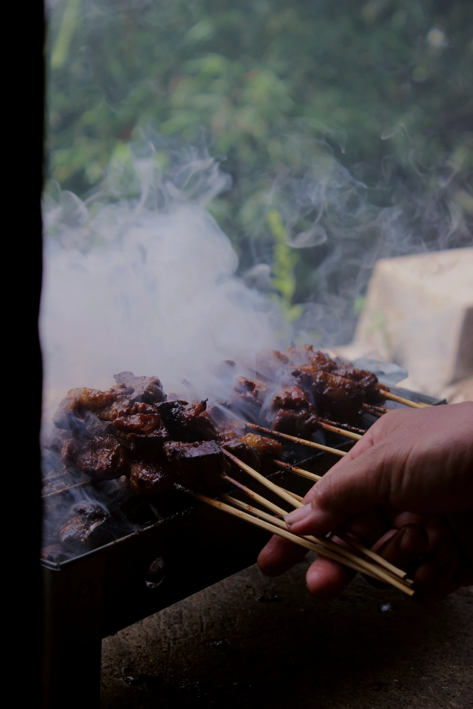 a person is pulling up some skewers on a grill