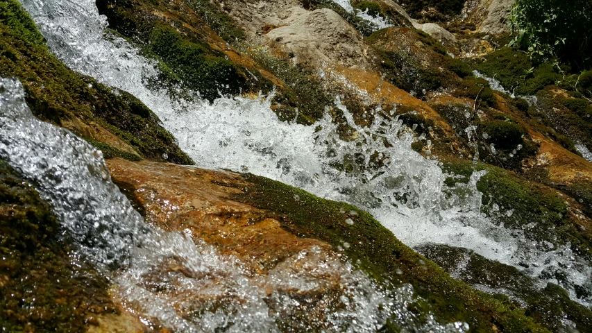 a man laying on the side of a waterfall