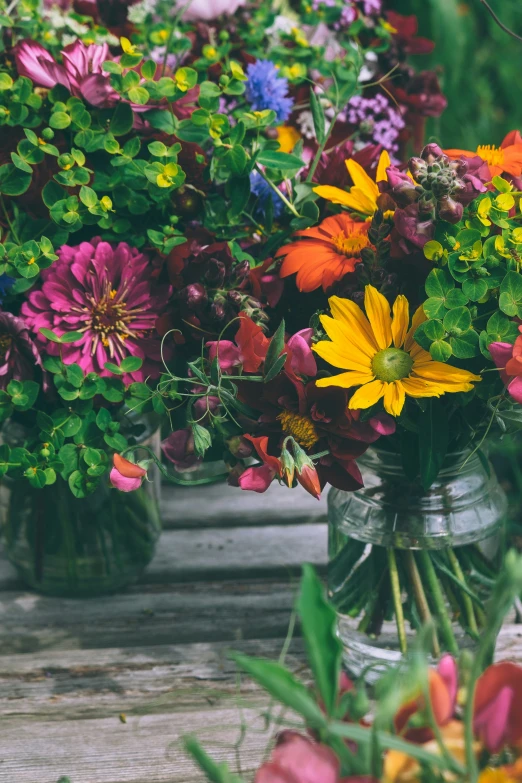 a group of different color flowers are in glass vases