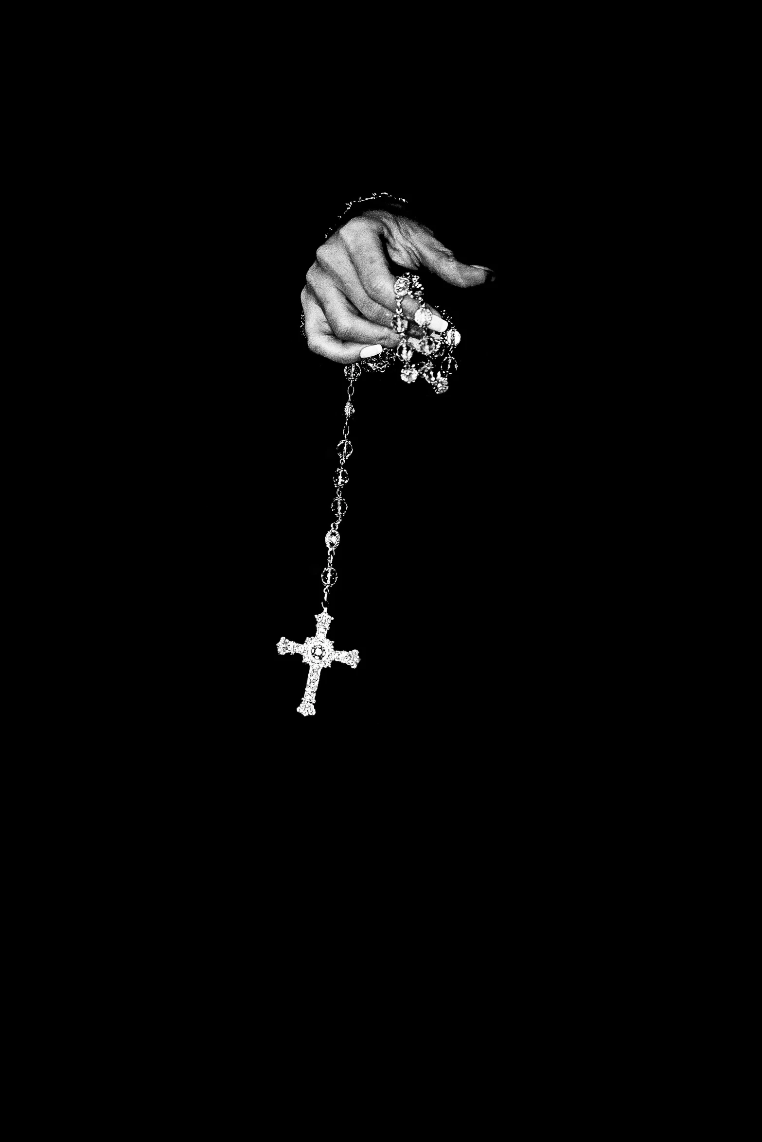 a hand that is holding a cross necklace