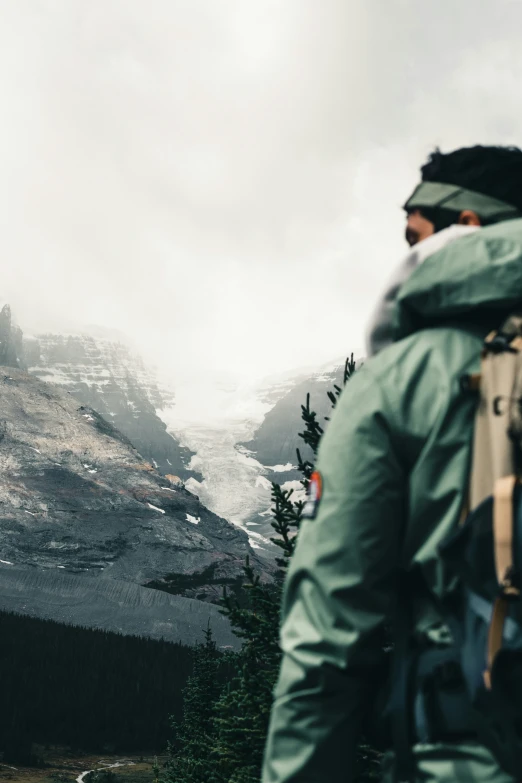 a person wearing a jacket and backpack overlooking a valley