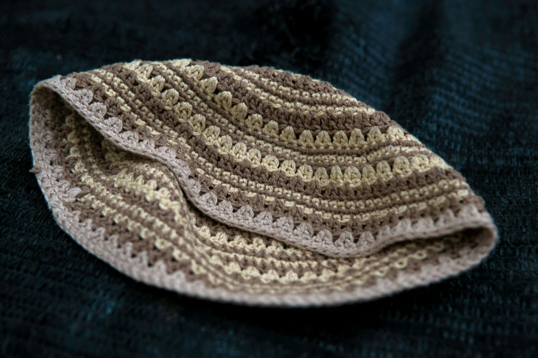 a brown and white crocheted piece of cloth