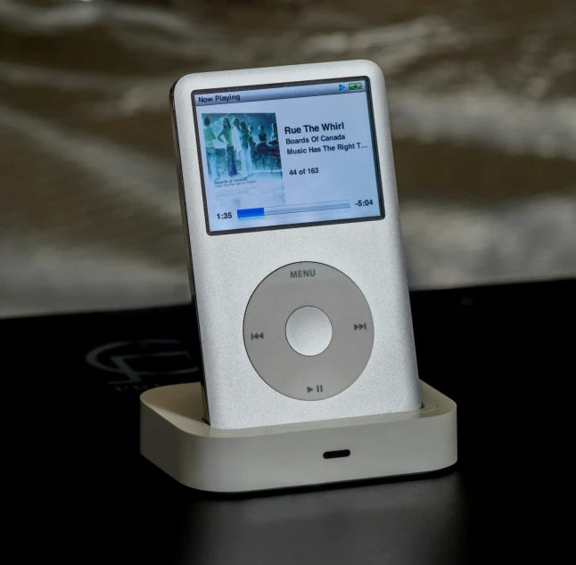 an ipod device sitting on a table with a screen