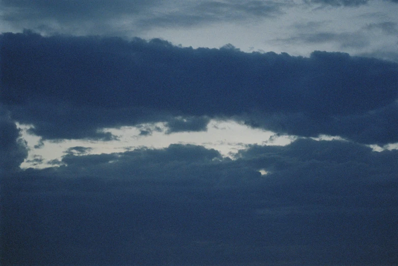 a plane is seen from under the clouds