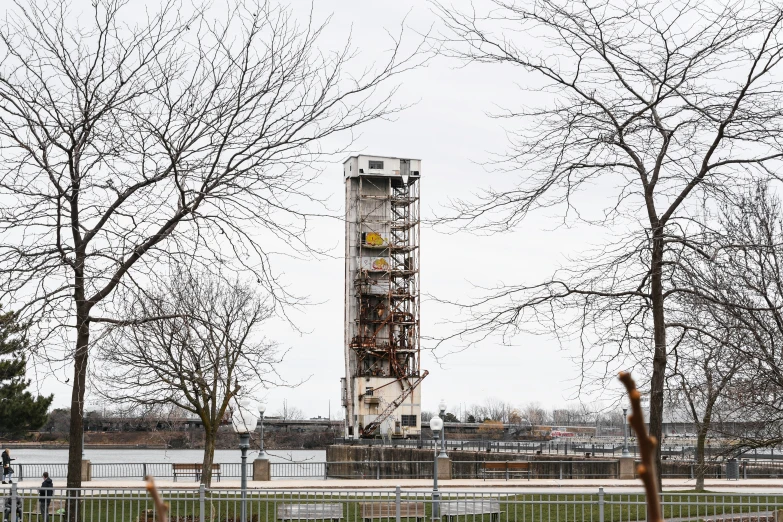 a very tall tower sitting next to a forest