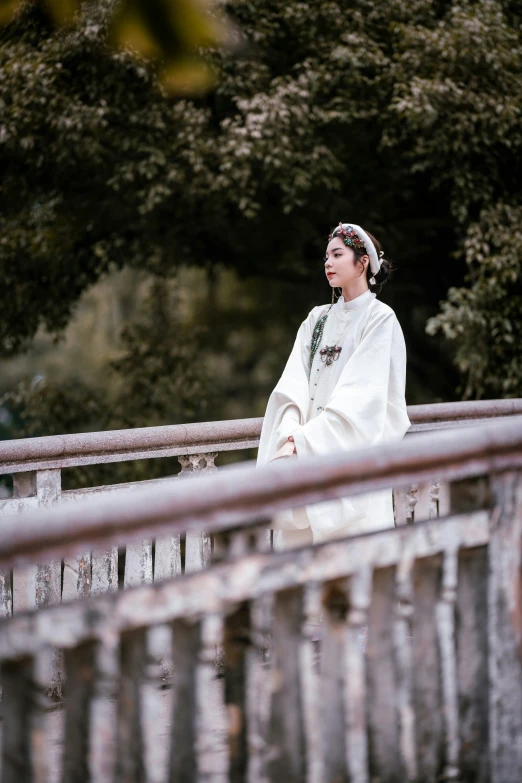 the woman wearing a traditional costume standing on a bridge