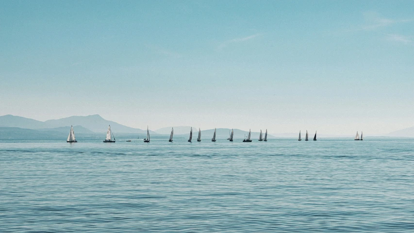 a bunch of small boats out in the middle of a large body of water