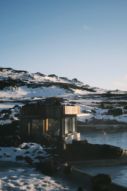 an outhouse sits amid a snowy mountainous area