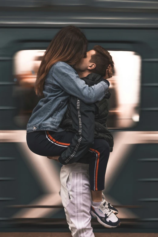 a young couple hug while riding on a moving train