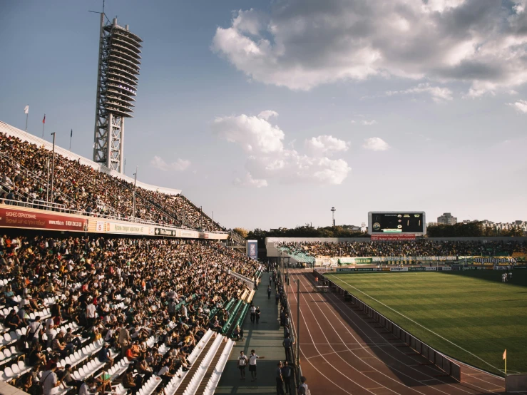 a stadium filled with people sitting in the stands and watching soing