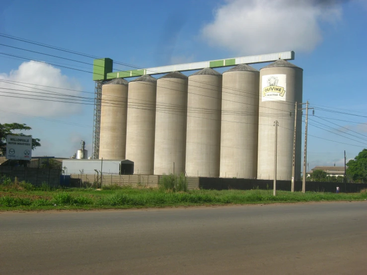 large industrial silos sitting along the side of a road