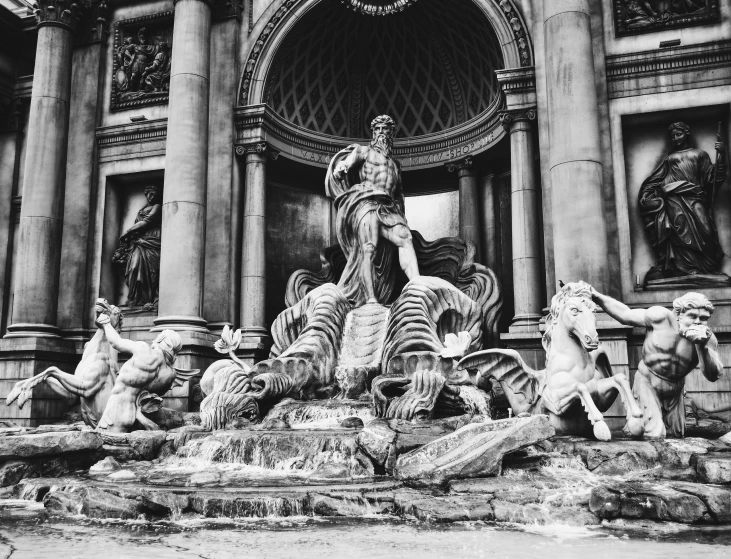 many statues are sitting on rocks near the entrance to a building