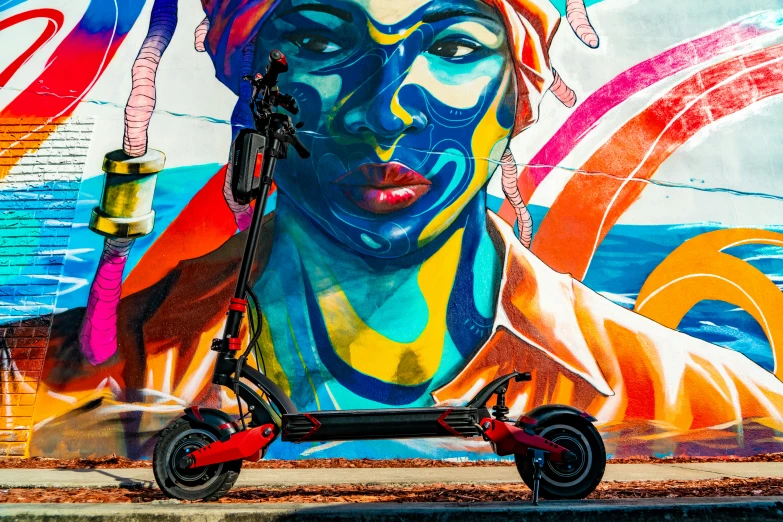 an older scooter sits in front of the mural