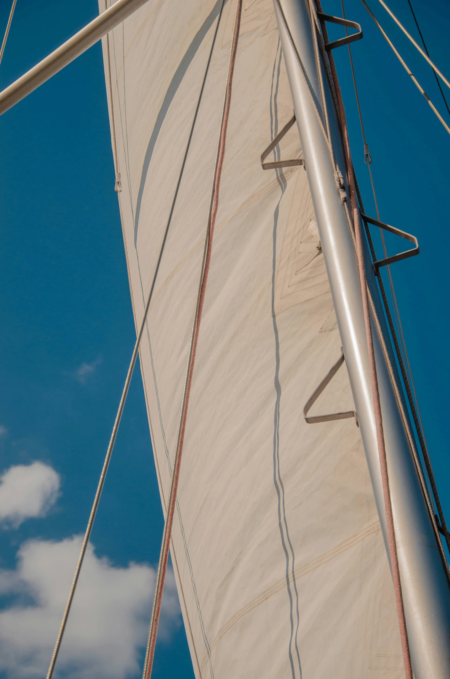 the sails and side of a sailing yacht in motion