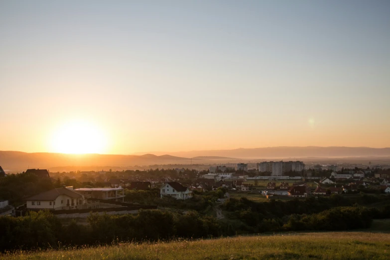 a large city and the sun setting over a rural town