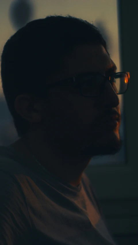 a man wearing glasses and staring ahead