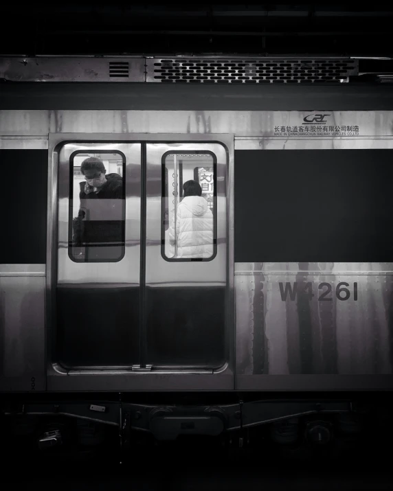 a black and white po of a man sitting in a train