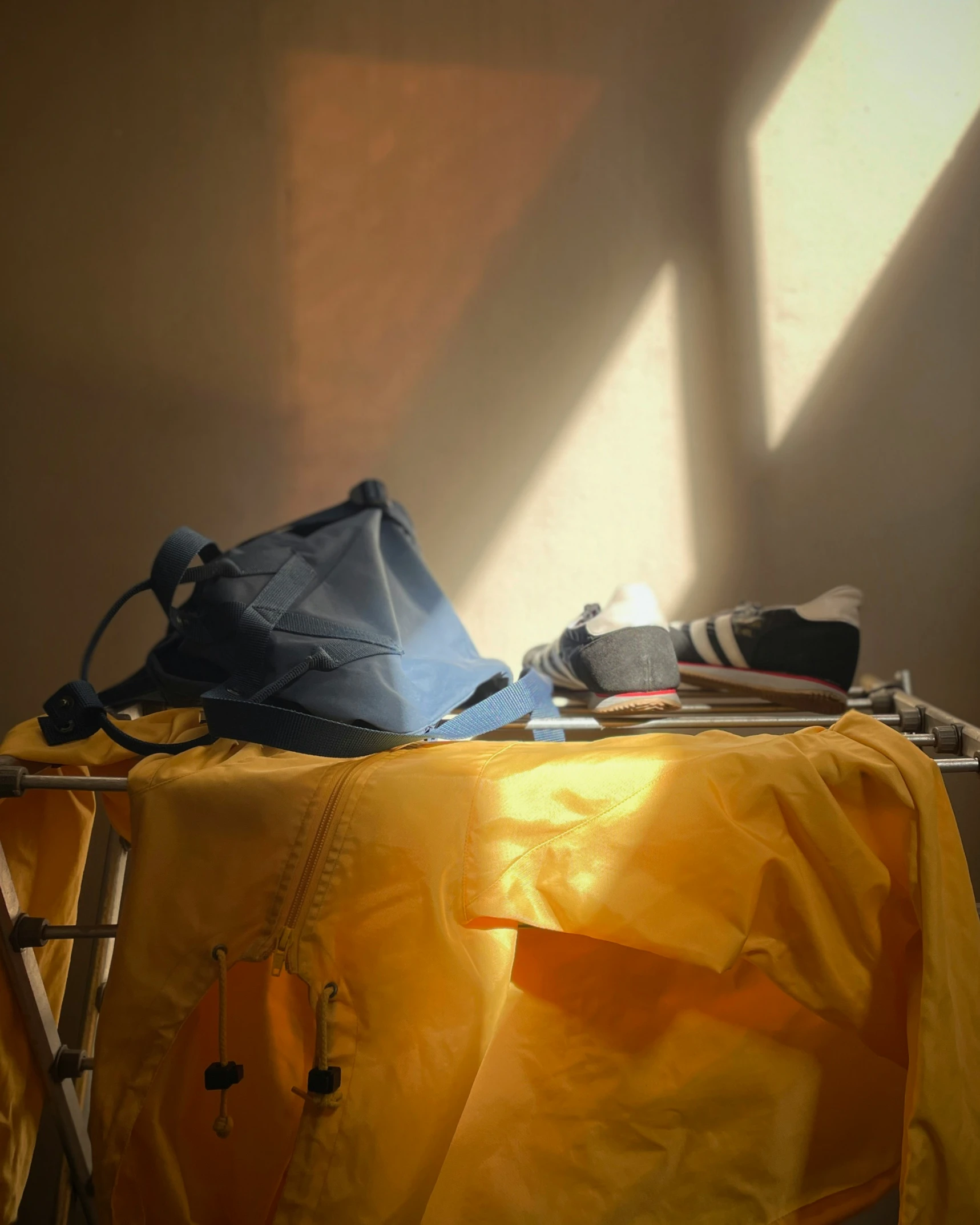 the sun is shining brightly on the room with several items laid out on a bed