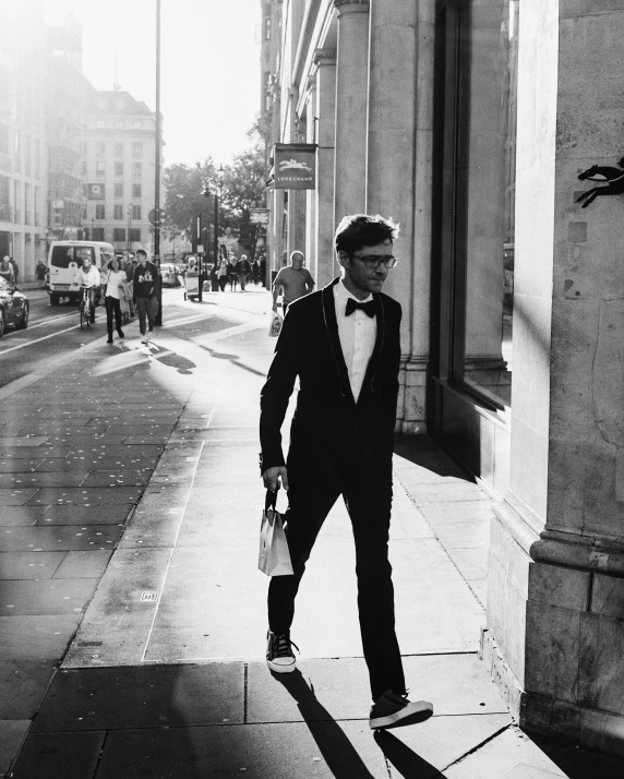 man in suit walking along the sidewalk near building