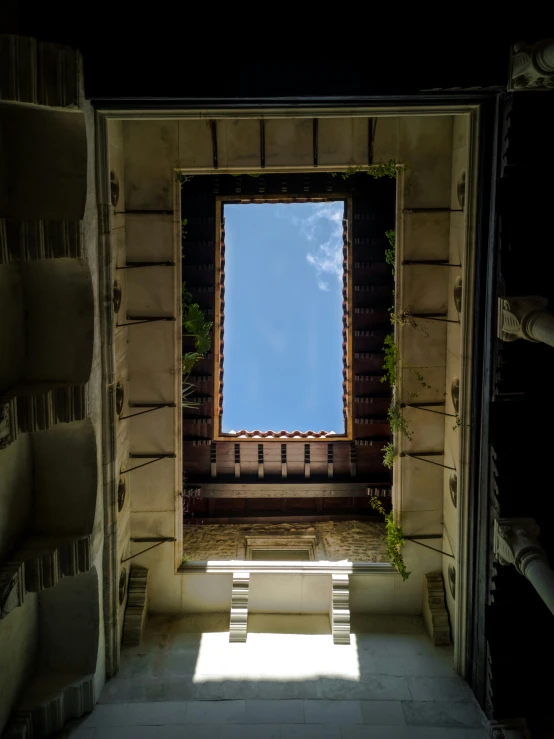 a window with a sunny blue sky seen from behind