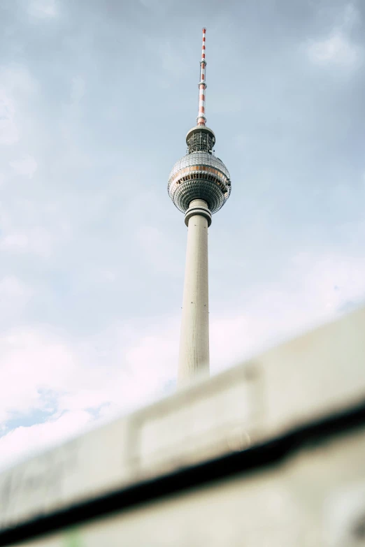 the tv tower in berlin is against a blue sky