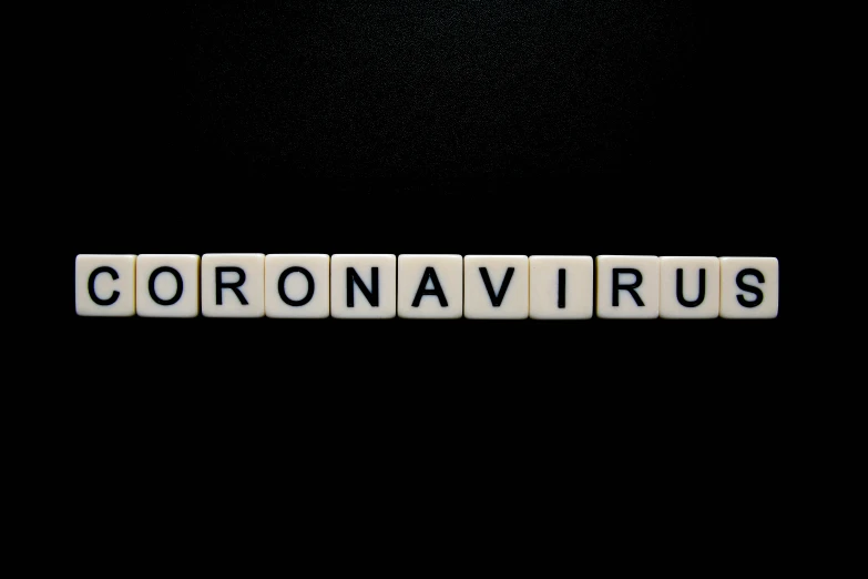 a crossword spelling coronavrus made out of letter tiles