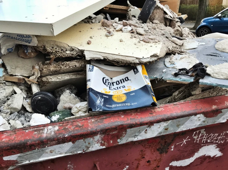 debris and boxes sitting in a dumpster next to a building