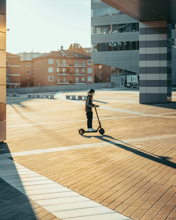 someone on an electric scooter and a tall building in the background