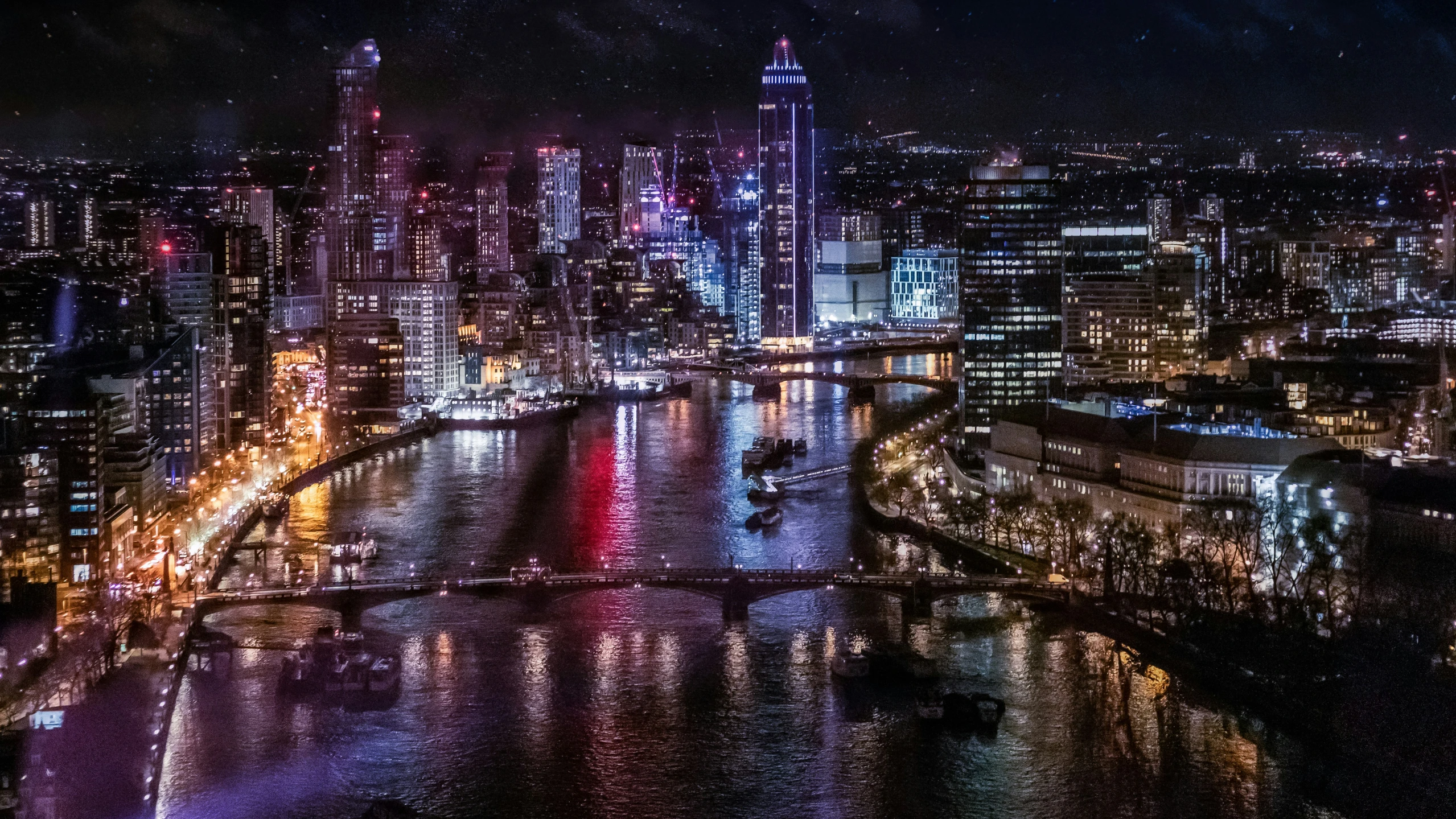 the city at night from an angle of a bridge