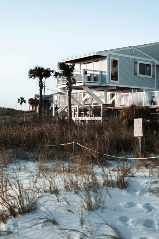 the beach with a building on top and several palm trees in the background