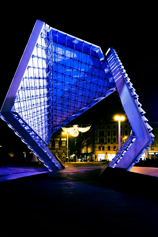 a very strange blue structure is lit up at night